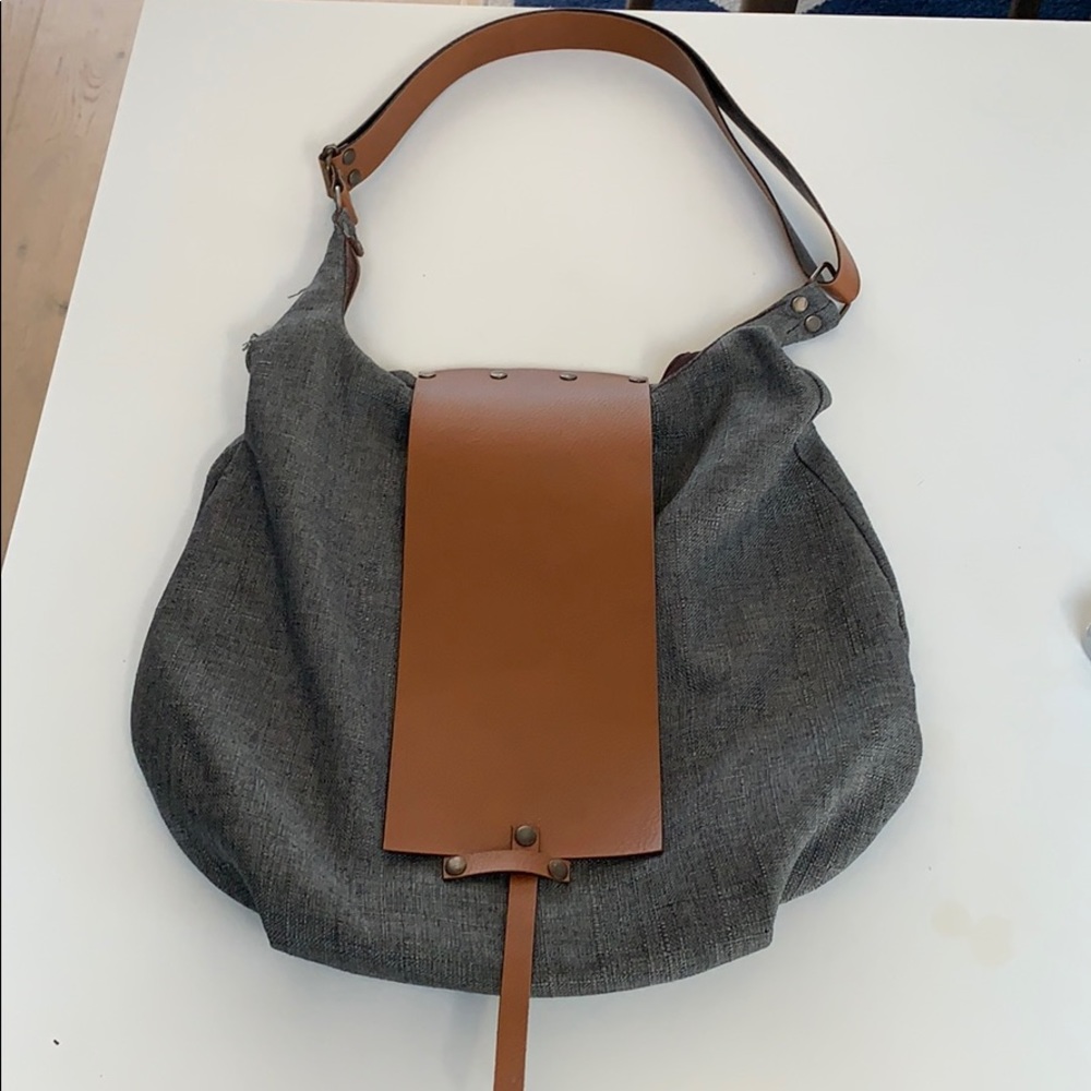 Leather strap and front clasp. Zippers shut.